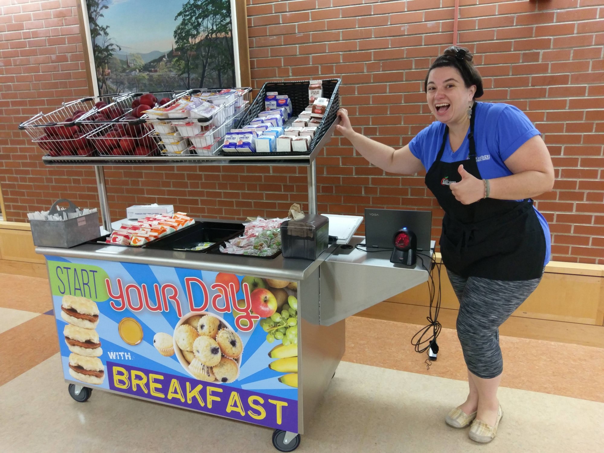 GFMS/TFHS cafeteria manager Liana Pleasant beside the grab-and-go cart, loaded with breakfast items